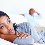 Unhappy woman lying in couch