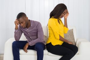 Couple Sitting Back To Back on Sofa