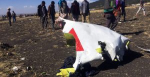 People walk past a part of the wreckage at the scene of the Ethiopian Airlines Flight ET 302 plane crash, near the town of Bishoftu, southeast of Addis Ababa
