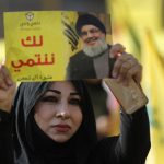 Woman protester holds photo of slain Hezbollah leader Sayyed Hassan Nasrallah