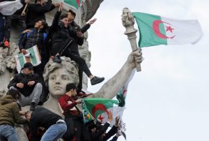 Protestors hold Algerian flags as they attend a demonstration against President Abdelaziz Bouteflika in Paris