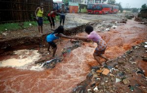 A woman crosses a flooded street in the aftermath of Cyclone Kenneth in Pemba