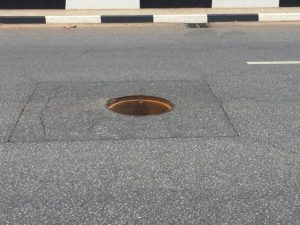 An-open-manhole-in-the-middle-of-a-paved-road-768×576