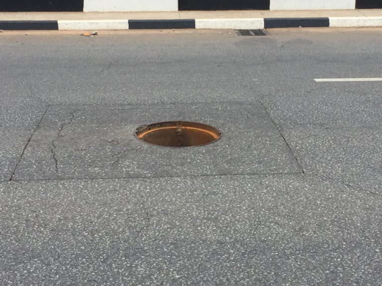 An-open-manhole-in-the-middle-of-a-paved-road-768×576