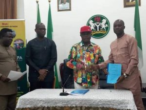 Gov Obiano handing over to Mr Sunday Ogbu a copy of signed MoU with Sunny Peace Cosmetics Ltd for production activities at Oba, Anambra State
