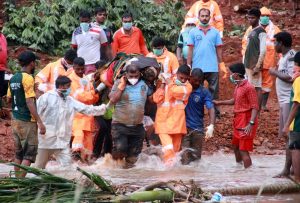 Rescuers carry the body of a victim after extracting it from the debris after a landslide caused by torrential monsoon rains in Kavalappara in Malappuram district