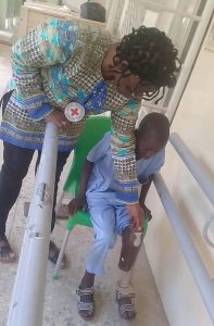 Sadiq-Muktar-being-assisted-by-ICRC-Ortho-Prosthetist-Ms-Idah-Kadyamatimba