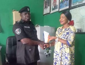 CSP Muktari Bello, the Divisional Police Officer (DPO) Enerhen, Uvwie Local Government Area of Delta state receiving the award from Ms Anita Aluya, the Publisher of Great Destiny Venture City News, an online media platform, in his office