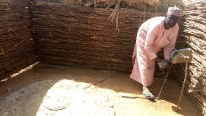Mr-Shehu-Adamu-of-Bunzugu-community-in-Gwandu-Local-Government-Area-of-Kebbi-State-washing-his-hands-using-a-tippy-tap-installed-in-the-toilet-for-his-households-300×169