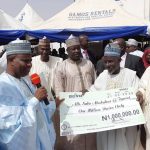 Tambuwal presenting a check to one of the loan beneficiaries