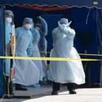A Health worker in a protective suit gestures in a tent erected to test for the new coronavirus at a clinic in Kuala Lumpur (AP)