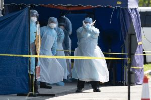 A Health worker in a protective suit gestures in a tent erected to test for the new coronavirus at a clinic in Kuala Lumpur (AP)