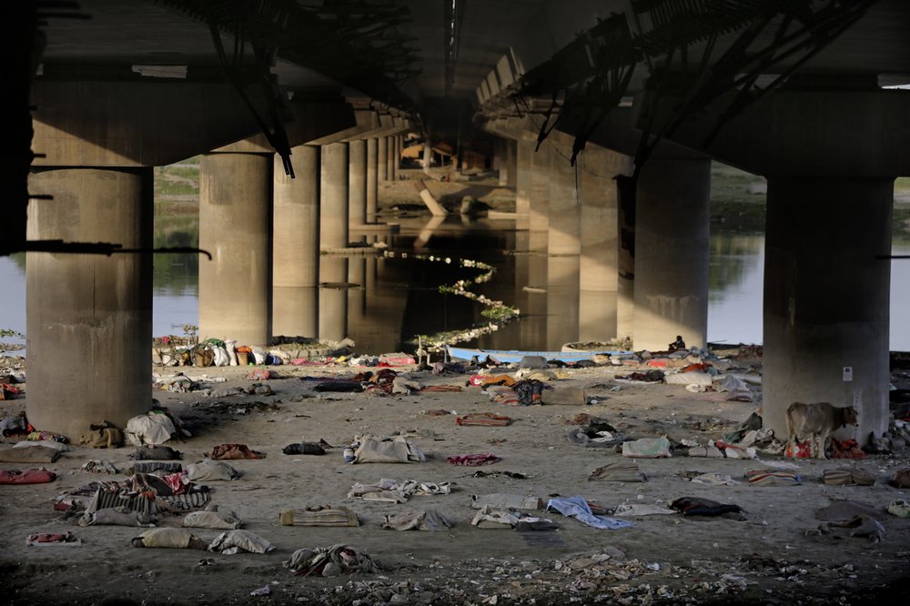 Beddings and other belongings of Indian migrant laborers and homeless people lie scattered after they were evicted from the banks of Yamuna River where they were squatting during lockdown in New Delhi, India, Wednesday, April 15, 2020. (AP Photo/Altaf Qadri)