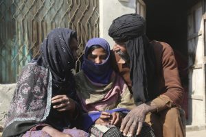 In this Feb. 5, 2020 photo, Mohammad Iqbal talks to her daughter Misbah, center, who was allegedly abused by her religious teacher in Leiyah, Pakistan (AP Photo/K.M. Chaudary)