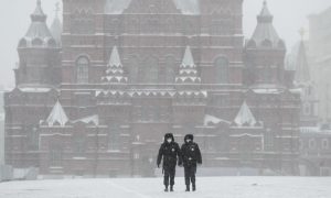 Police officers cross an empty Red Square in Moscow, Russia. The Russian capital woke up to a lockdown in response to coronavirus, obliging most people in the city of 13 million to stay home. Photograph: Pavel Golovkin/AP