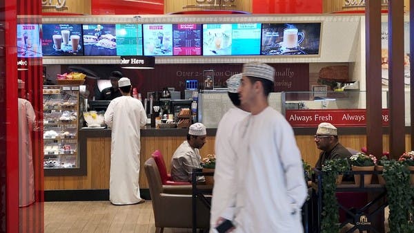 Omani men pass in front of Canadian cafe and bake shop Tim Hortons in City Center Mall in Muscat, Oman. (File photo: Reuters)