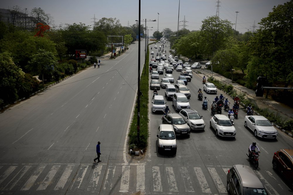Indians leave for work in cars and motorcycles in the morning in New Delhi. (AP Photo/Manish Swarup)