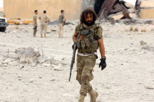 Member of Libya’s internationally recognised government holds his weapon after taking control of Watiya airbase
