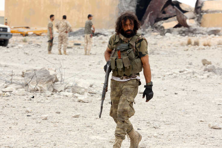 Member of Libya’s internationally recognised government holds his weapon after taking control of Watiya airbase