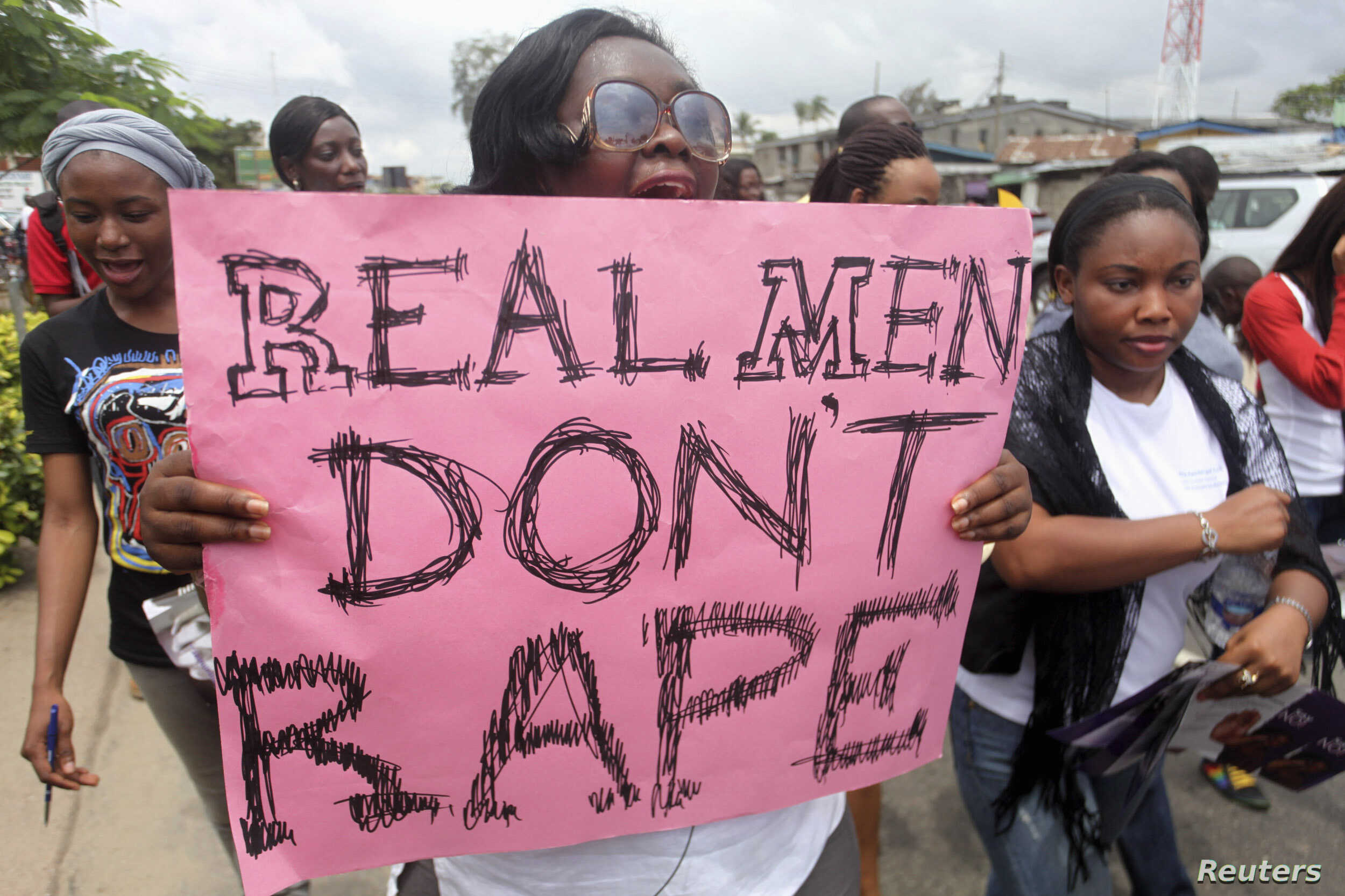 A woman carries a placard as she shouts a slogan during the “walk against rape'” procession organised by “Project Alert”, a Lagos-based NGO focusing on women’s issues, in Lagos