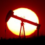 The sun sets behind a pump-jack outside Saint-Fiacre