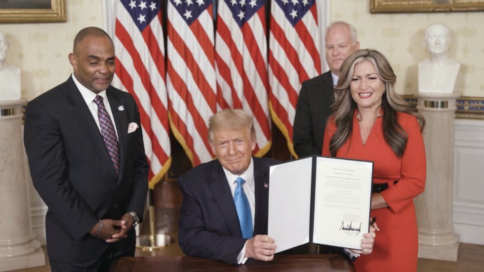 Jon Ponder (L) and his wife Jamie Ponder (R) look on as President Donald Trump signs a document granting clemency to Ponder during the virtual convention on Aug. 25, 2020. (Photo Courtesy of the Committee on Arrangements for the 2020 Republican National Committee via Getty Images)