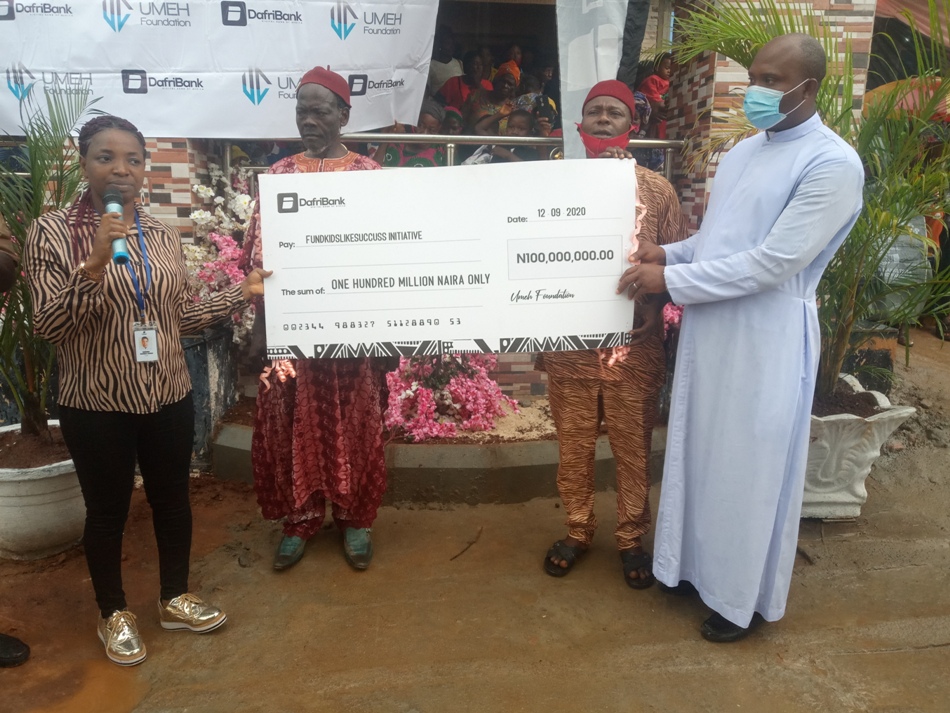 Staff of DafriBank Limited, Onos Oma, handing over a dummy cheque of N100 million Fund Kids Like Success Initiative to the representatives of Ezinifite community. PHOTO. OBINNA ODOGWU