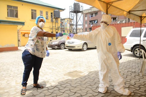 A health worker collecting sample test kits from a nurse during a community COVID-19 testing campaign in Lagos. Photo by Olukayode Jaiyeola/NurPhoto via Getty Images
