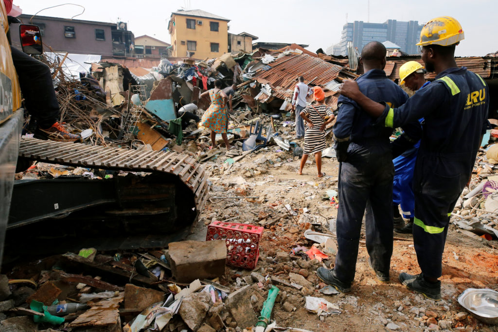 Rescuers are seen as people search for belongings at the site of a collapsed building in Nigeria’s commercial capital of Lagos