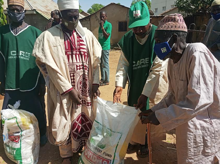 Second Left: Village Head M Musa handing over a package to disabled elder M Inuwa