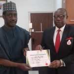 Rt Hon Jarigbe, left, receiving the CoR from Festis Okoye, right, INEC Commissioner in charge of Information and Voter Education