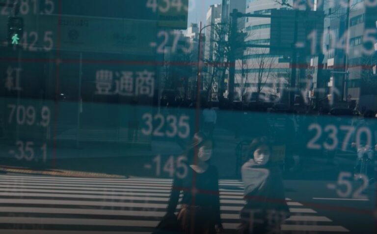 People wearing protective face masks, following an outbreak of the coronavirus, are reflected on a screen showing Nikkei index, outside a brokerage in Tokyo, Japan Feb. 28, 2020. (Reuters file photo)