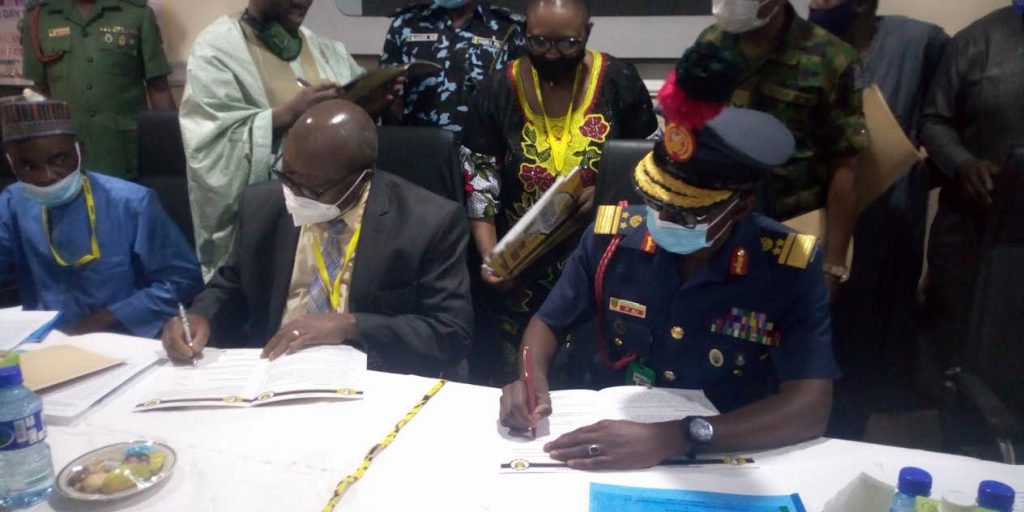 Director General NMDC Prof Linus Asuquoand Representative of the Commandant NDA signing Memorandum of Understanding on development solid Minerals in Nigeria