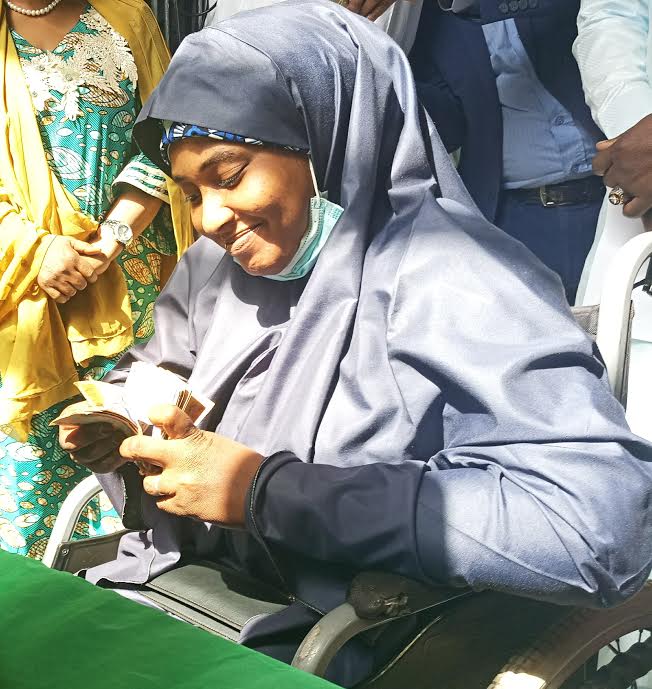A beneficiary, Mariam Abubakar, confirming her N20,000 cash grant in Kaduna on Wednesday  (Photo credit: Sola Ojo)