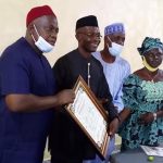 Chief displays his BoT membership certificate with NANFACOS executive in Nnewi