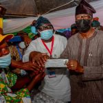 Former Ogun State Governor Gbenga Daniel being given his APC membership card, shortly after he validated his membership of the party