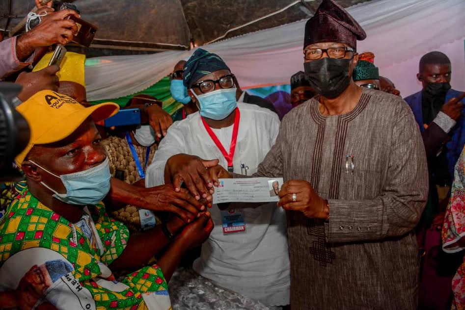 Former Ogun State Governor Gbenga Daniel being given his APC membership card, shortly after he validated his membership of the party