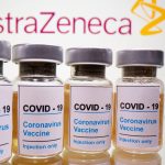 FILE PHOTO: Vials and medical syringe are seen in front of AstraZeneca logo in this illustration