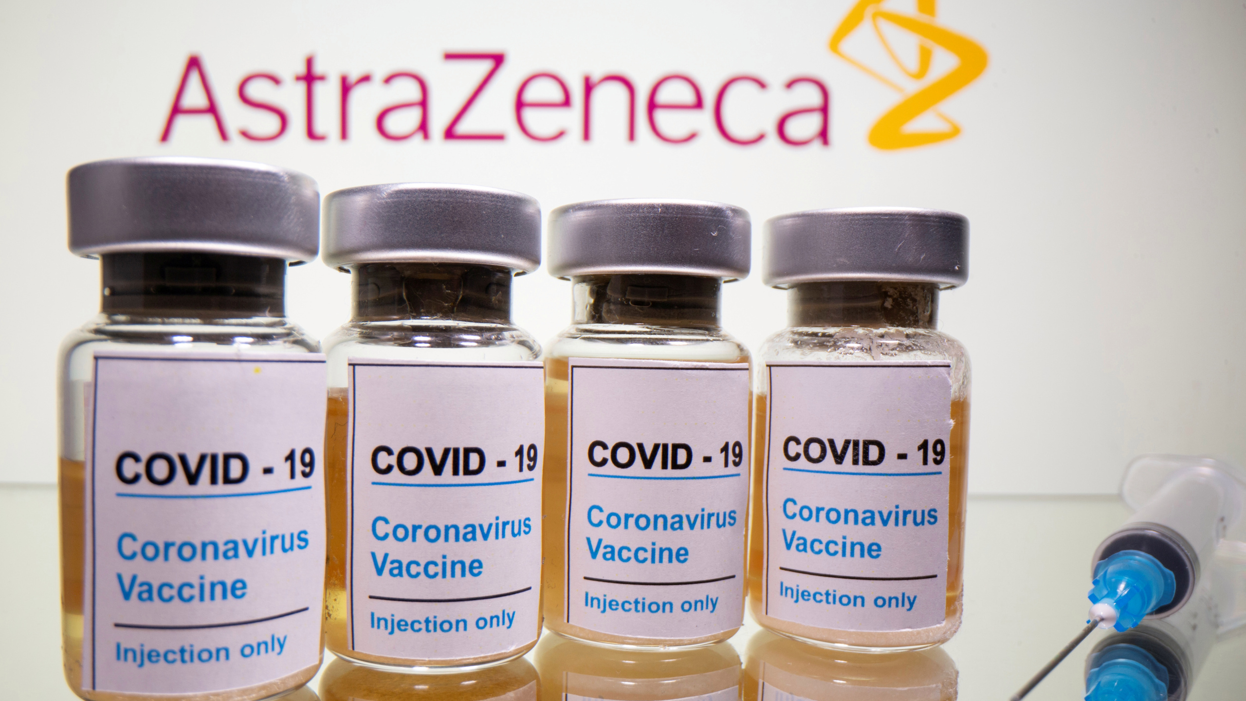 FILE PHOTO: Vials and medical syringe are seen in front of AstraZeneca logo in this illustration