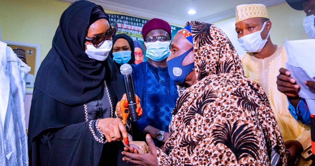 Minister of Humanitarian Affairs Sadiya Umar Farouq (L) and a cash grant beneficiary