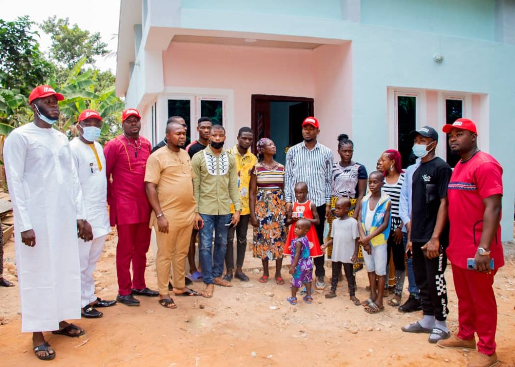 The benefactor and friends posing with the beneficiary infront of the new house