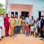 The benefactor and friends posing with the beneficiary infront of the new house