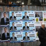 Woman walks past election posters of the ruling centre-right GERB party in the town of Dupnitsa