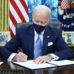 President Joe Biden signs executive orders inside the Oval Office at the White House in Washington