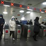 Commuters wearing face masks to protect against COVID-19 exit a subway station in the central business district in Beijing, Thursday, Dec. 23, 2021. China ordered the lockdown of as many as 13 million people in neighborhoods and workplaces in the northern city of Xi’an following a spike in coronavirus cases, setting off panic buying just weeks before the country hosts the Winter Olympic Games. (AP Photo/Mark Schiefelbein)