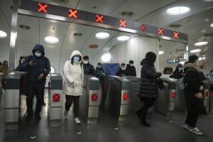 Commuters wearing face masks to protect against COVID-19 exit a subway station in the central business district in Beijing, Thursday, Dec. 23, 2021. China ordered the lockdown of as many as 13 million people in neighborhoods and workplaces in the northern city of Xi’an following a spike in coronavirus cases, setting off panic buying just weeks before the country hosts the Winter Olympic Games. (AP Photo/Mark Schiefelbein)