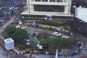 People wait for the coronavirus testing outside a public health center in Seoul, South Korea, Wednesday, Dec. 15, 2021. Halting its steps toward normalcy, South Korea will clamp down on social gatherings and cut the hours of some businesses to fight a record-breaking surge of the coronavirus that has led to a spike in hospitalizations and deaths. (AP Photo/Ahn Young-joon).