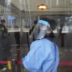 A medical worker guides people as they wait for their coronavirus test at a makeshift testing site in Seoul, South Korea, Thursday, Dec 16, 2021. (AP Photo/Ahn Young-joon)