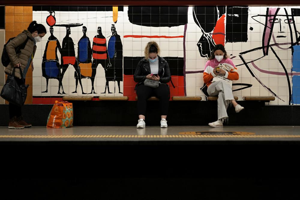People wearing face masks to help curbing COVID-19 virus spread wait for a train at a subway station in Lisbon, Tuesday, Dec. 7, 2021. Despite having one of the highest vaccination rates in Europe, with 86.6% of its 10.3 million people inoculated, Portugal is scaling up its pandemic response amid the emergence of the omicron variant. (AP Photo/Armando Franca)