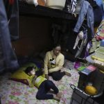 Noraida Gmama, 40, sits by her three-year-old undocumented daughter Aliha, in their small, shabby apartment shared with a half-dozen people, in Sharjah, United Arab Emirates, Monday, Dec. 6, 2021. Unmarried, she gave birth in secret at home and is now struggling to figure out how to document her toddler who cannot travel, enroll in school or go to a public hospital without a birth certificate. (AP Photo/Kamran Jebreili)
